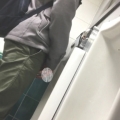 A male is pissing in the toilet.