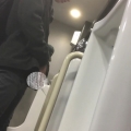A male is pissing in the toilet.